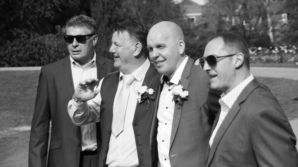 Men together at a wedding smiling